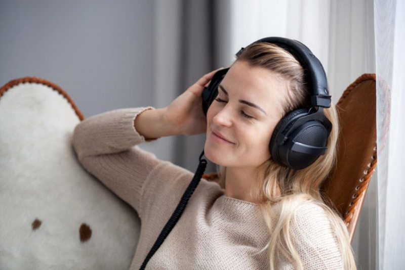 Young woman wearing headphones listening to music and relaxing a